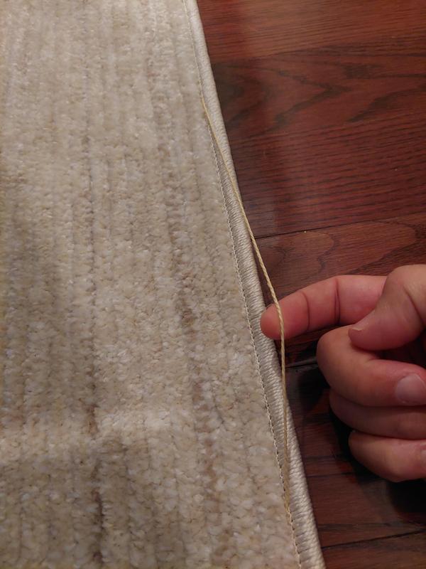 Customer photo for review titled "The rug arrived with defect it is unstitched....."