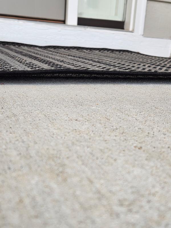 Customer photo for review titled "Rugs curls up on edges- tripping hazard"